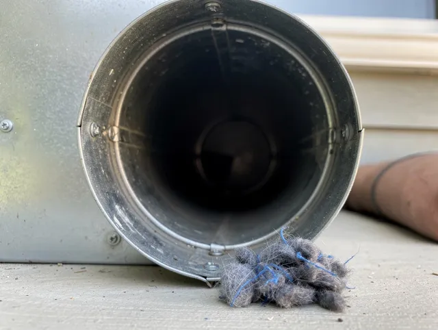 Green Dryer Vent Cleaning technician using specialized equipment to clear severe dryer vent blockage in Green
